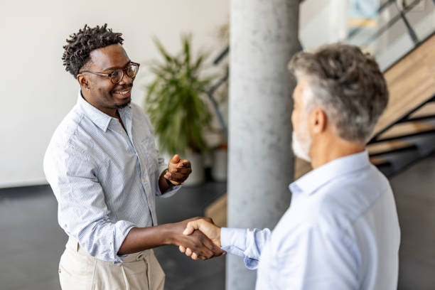 istock Two Businessmen Shaking Hands in a Modern Office Setting 2202380594