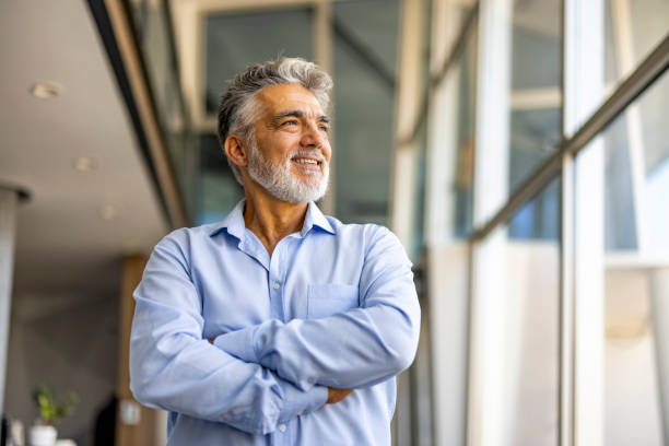 Confident Mature Man Standing in Modern Office Environment