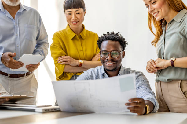 istock Diverse Team Collaborating and Reviewing Documents in Office 2202380693