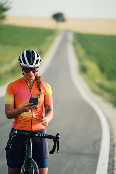 istock A woman checks a message on her cellphone while biking. 2202381639