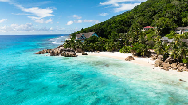 istock Tropical beach with palm trees and turquoise ocean. Seychelles, La Digue. 2202390073