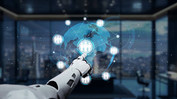 istock Futuristic robotic hand interacting with digital global network and human figures in modern office environment representing technology and connectivity. Auvana 2202390536