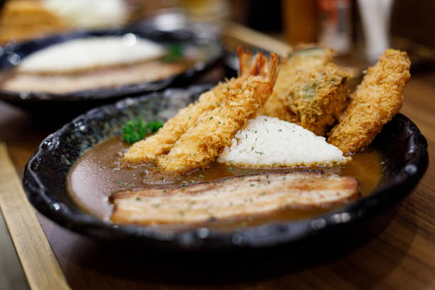 Delicious Japanese style curry rice topped with deep fried shrimp on plate. Selective focus.