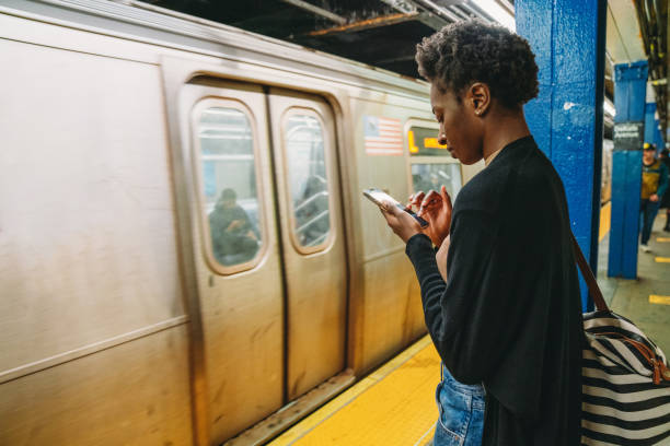 istock A woman is using a smartphone while she's waiting for the train in a subway station 2202396444