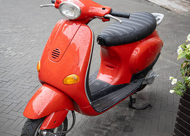 istock a red retro moped is standing on the street. 2202396978
