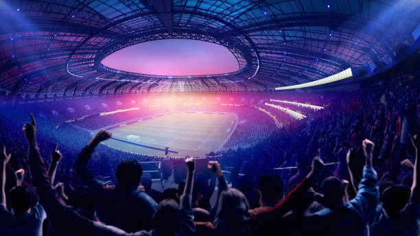 istock Fans raising hands, celebrating game under colorful sky, bright stadium lights illuminating massive football field. 3D render, fisheye view. Composite collage 2202397590