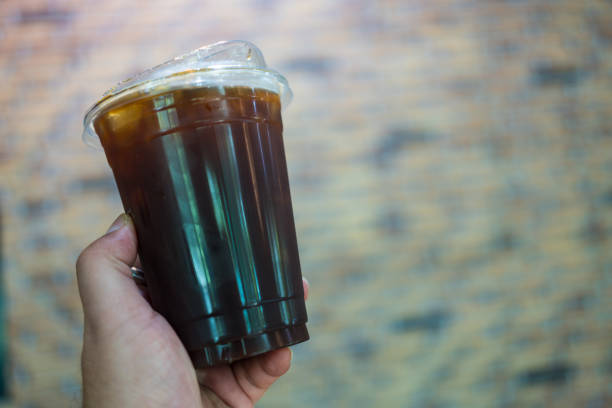 istock Unrecognizable holding a cup of iced black coffee 2202404552