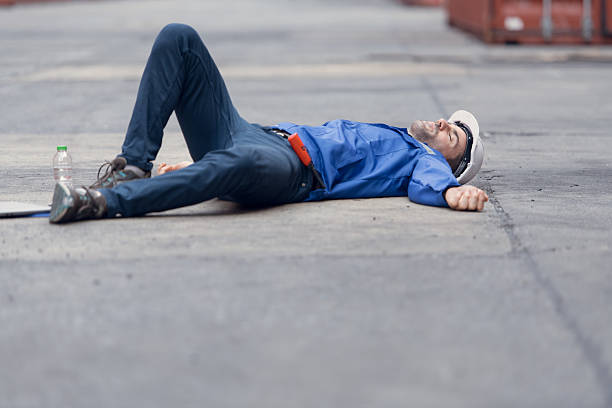 istock A worker in a container warehouse fainted while working in the bright sunlight and hot weather of a container storage yard 2202407534