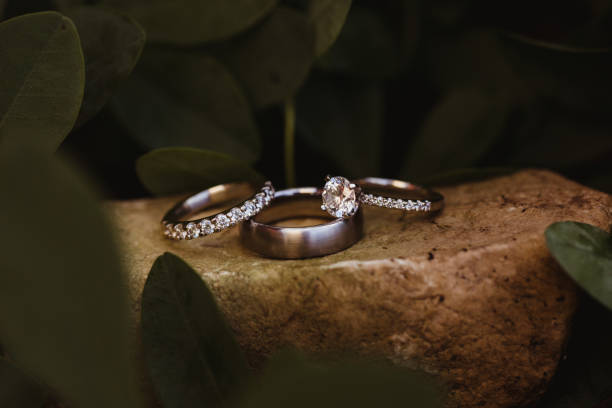 Close up of wedding rings with diamonds outdoors on wet stone