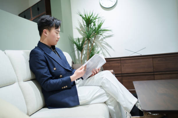 Man sitting on sofa reading a book