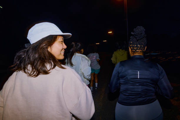 Group of Gen Z runners, running together at night
