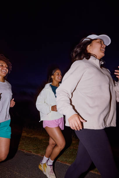 istock Group of Gen Z runners, running together at night 2202418723