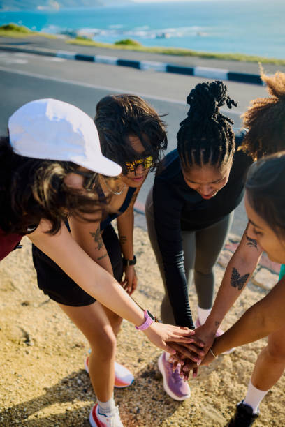istock Group of gen z female runners stacking hands and smiling 2202418738