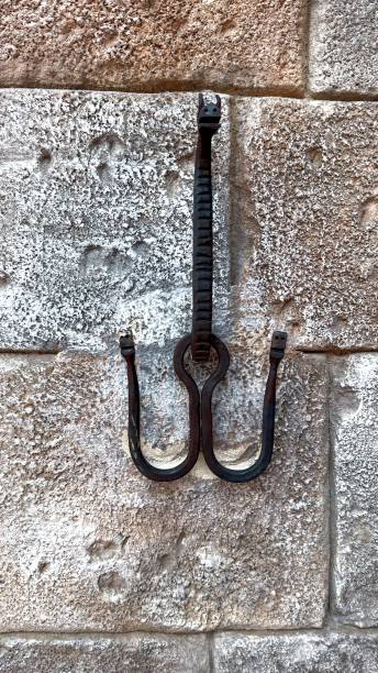 istock Rustic metalwork and stone showcasing rugged metal hook set against textured stone wall, highlighting traditional craftsmanship and enduring strength of raw materials in rustic settings 2202423507