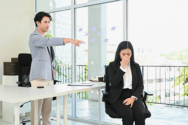 istock A man points at a woman who is crying in a business setting. 2202427994