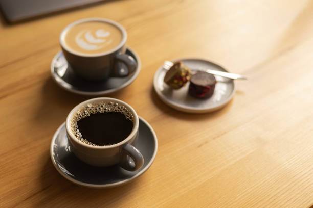 istock two cups of coffee and a plate with sweets on a table in a cafe 2202430251