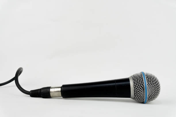 istock A black microphone with a blue ring lies horizontally on a clean white background, cable gently curving. 2202433652