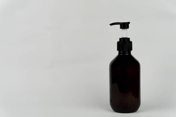 istock An amber-colored pump bottle is placed against a white backdrop, perfect for showcasing cosmetic or skincare products. 2202433667