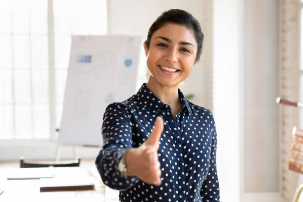 istock Attractive professional Indian woman extends her hand forward to camera 2202433702