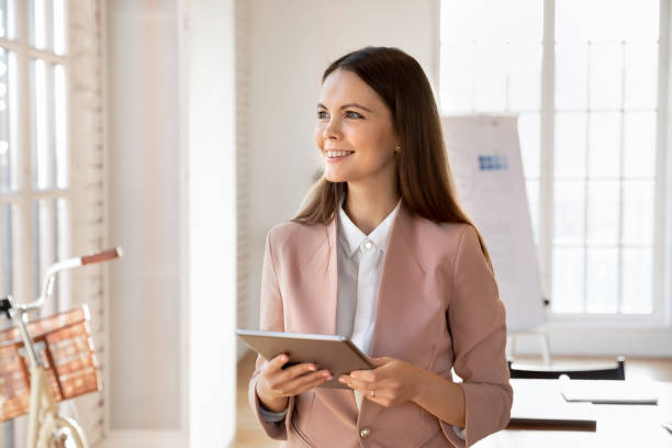 istock Creative businessperson standing in modern office with digital tablet 2202437526