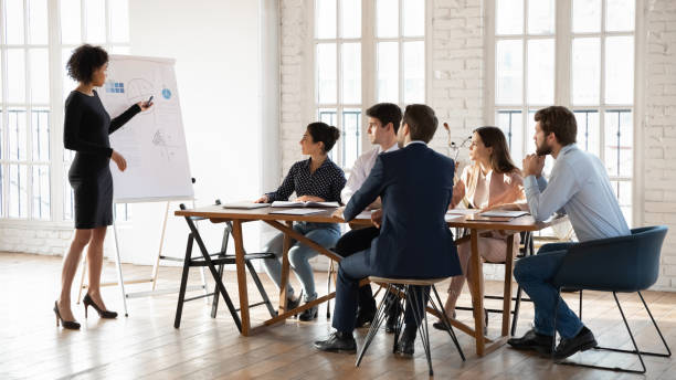 istock African woman presenter makes presentation on flip chart for shareholders 2202440390