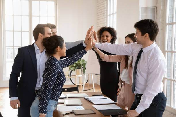istock Happy multiethnic workmates giving each other high-fives 2202443715