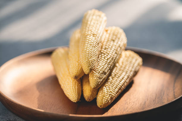 Baby corn on a wooden plate macrophotography