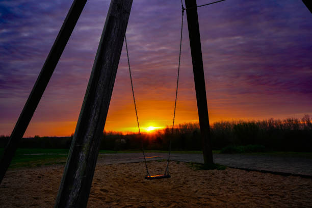 Swing in the rising sun on a small artificial mountain in the city of Oldenburg-Germany.