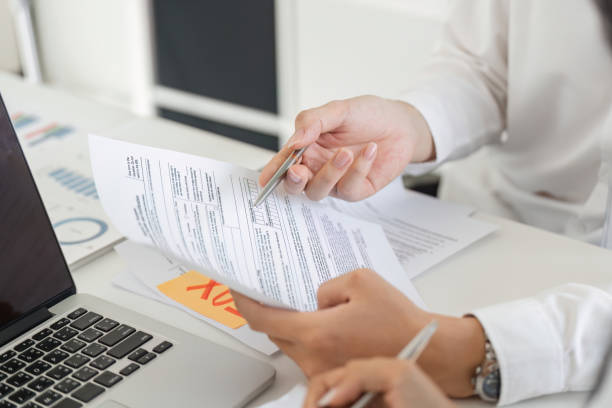 istock Professional worker reviewing tax documents and calculations at a desk 2202445949