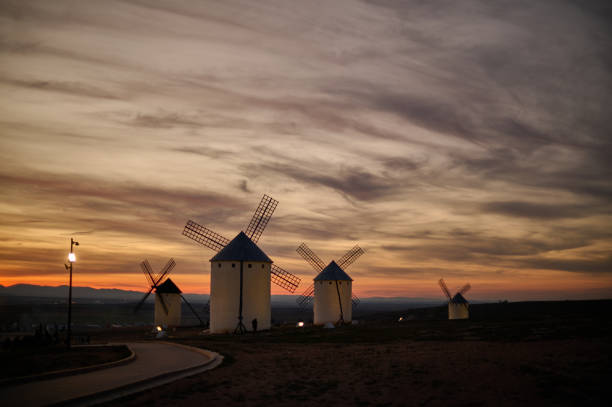 istock Sunset over the windmills of Campo de Criptana, casting a golden glow on the iconic landscape of Castilla-La Mancha, Spain, famously linked to Don Quixote 2202446875