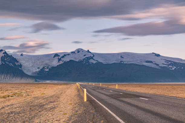 istock Open road leading to Icelandic glacier-covered mountains at dusk 2202448057