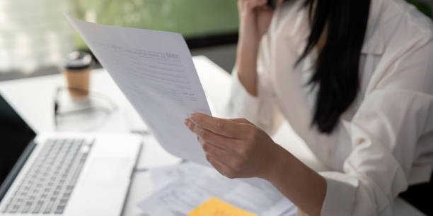 istock Focused professional analyzing tax paperwork in a modern office setting. 2202448469