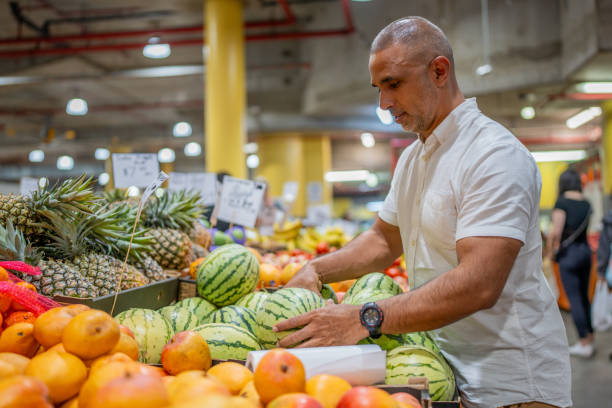 istock Pakastani Man Selecting Fruit at a Market 2202449634