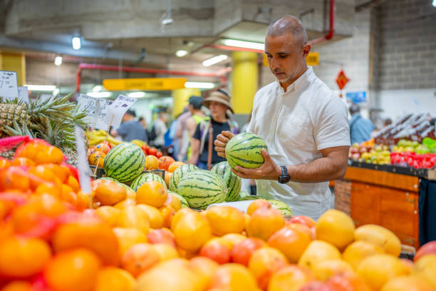 Middle Eastern Man Inspecting a Watermelon at a Market