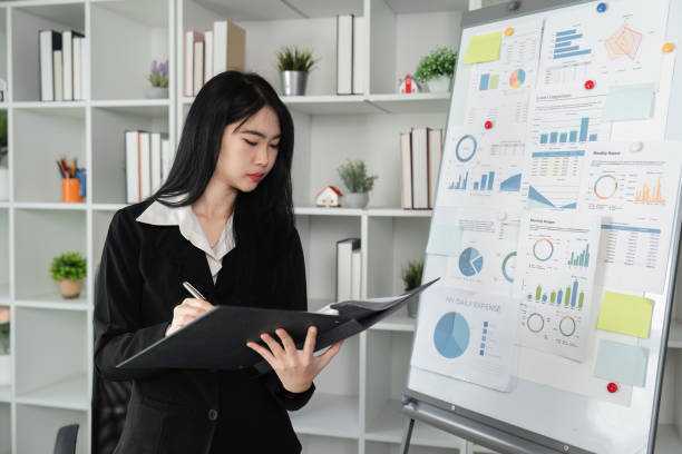 istock Focused accountant analyzing financial reports and charts in a modern office setting. 2202450982