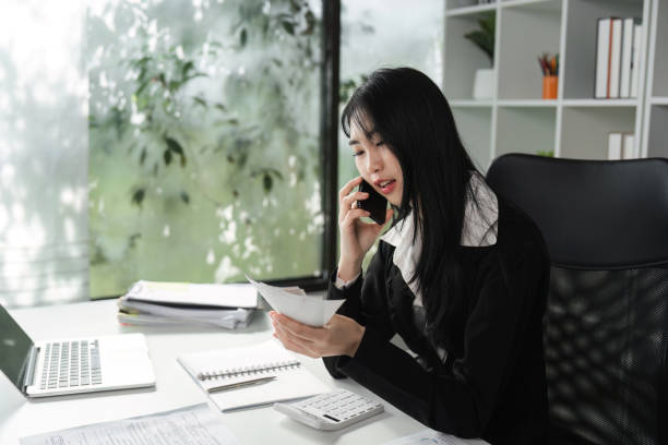 istock Accountant on the phone discussing financial matters while reviewing documents. 2202451195