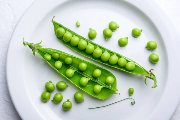 istock Crisp sugar snap peas on a clean white dish 2202451573