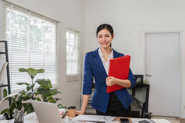 istock Businesswoman reviewing financial documents in a modern office setting, showcasing professionalism and organization. 2202453095