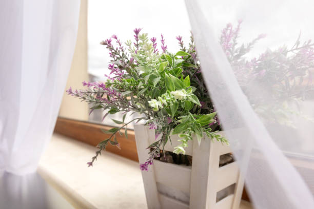 istock Artificial plant purple flower on window sill 2202453105
