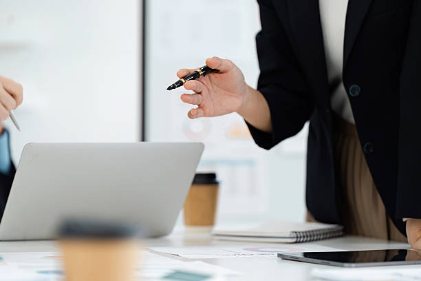 istock Business professional presenting ideas with a pen during a collaborative meeting in a modern office. 2202453382