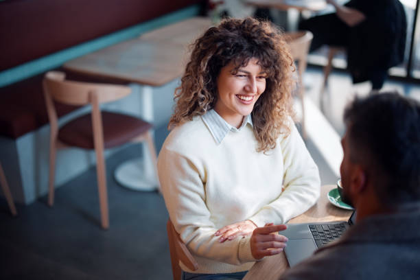 istock Smiling Woman Having a Meeting in a Modern Cafe Setting 2202454508