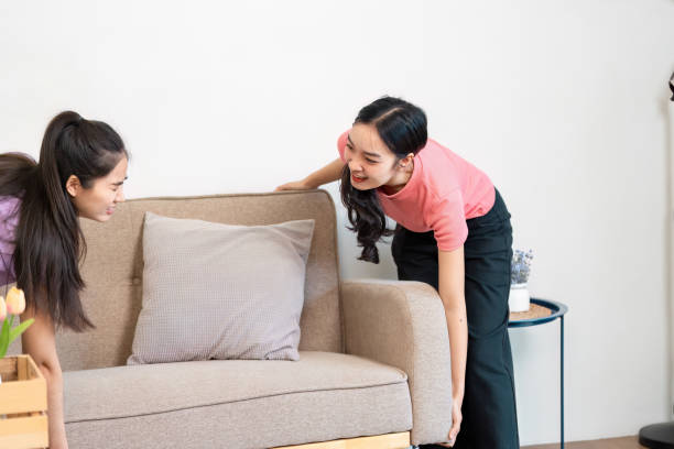 istock LGBTQ couple collaboratively moving a sofa into their new home, reflecting teamwork and love in their shared space. 2202455512