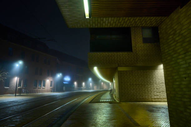 Night scenes in city covered in haze and fog. No people in spooky cityscape.