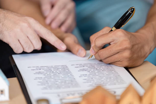 istock Diverse individuals signing a contract together, emphasizing collaboration and partnership in a professional setting. 2202456736