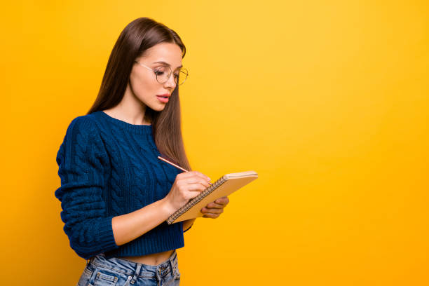 istock Profile side view portrait of her she nice-looking attractive winsome focused intelligent straight-haired girl writing to-do check list isolated over bright vivid shine yellow background 2202456741