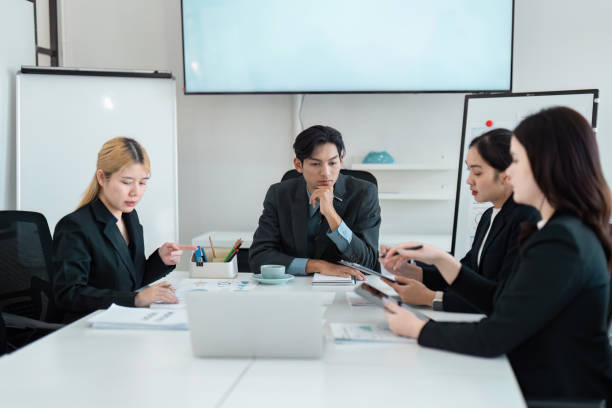 istock Diverse business team engaged in a focused strategy meeting, analyzing data and discussing solutions to enhance collaboration. 2202457520