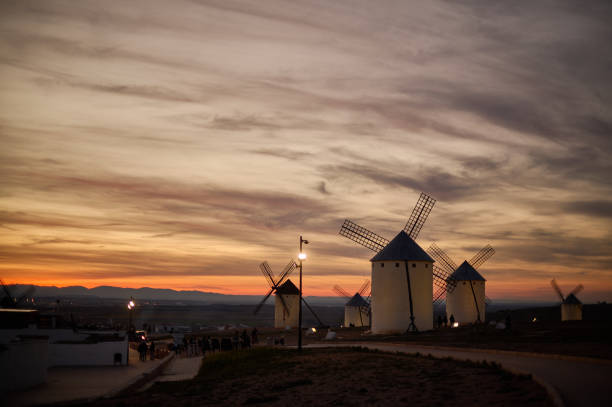 istock Sunset over the windmills of Campo de Criptana, casting a golden glow on the iconic landscape of Castilla-La Mancha, Spain, famously linked to Don Quixote 2202457765