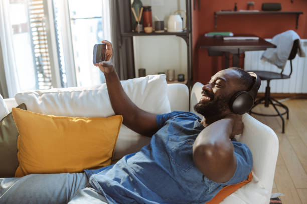 istock Relaxed African American man consuming online content on smartphone at home 2202458083