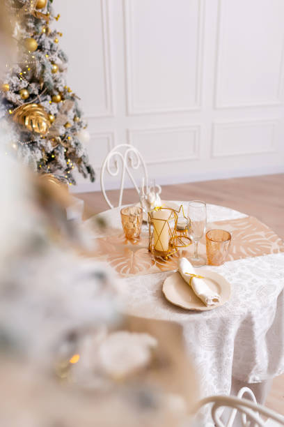 istock New Year's table setting in a photo studio. Plates with glasses on a Christmas tablecloth 2202459537