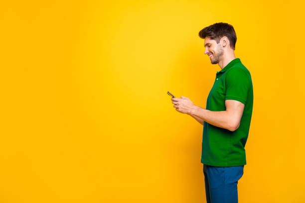istock Profile side view portrait of his he nice attractive cheerful cheery addicted guy using digital device smm like isolated over bright vivid shine vibrant yellow color background 2202459652